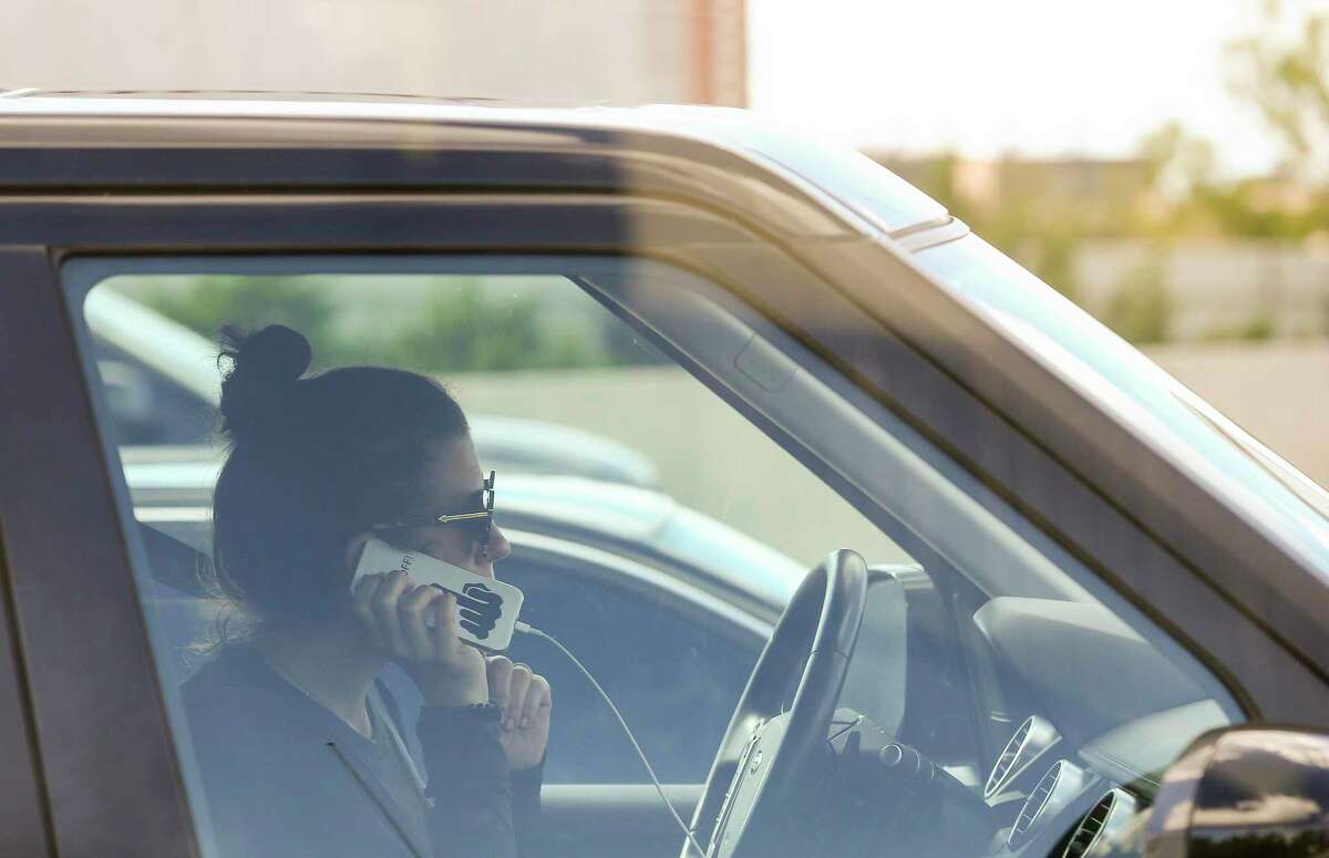 A motorist uses a cell phone while driving.