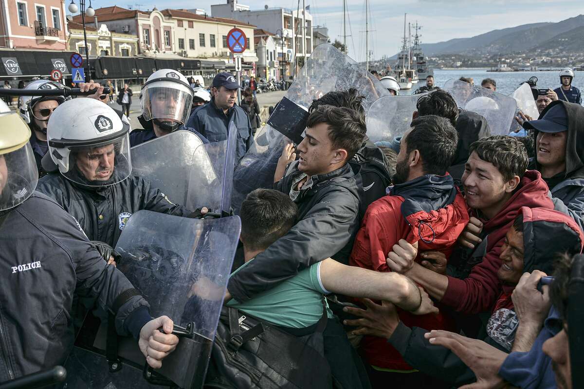 Migrants scuffle with Grek police at the port of Mytilene after locals block access to the Moria refugee camp, on the northeastern Aegean island of Lesbos, Greece, on Tuesday, March 3, 2020. Migrants and refugees hoping to enter Greece from Turkey appeared to be fanning out across a broader swathe of the roughly 200-kilometer-long land border Tuesday, maintaining pressure on the frontier after Ankara declared its borders with the European Union open. (AP Photo/Panagiotis Balaskas)