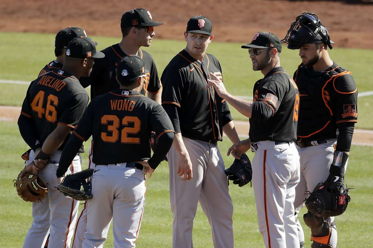 San Francisco Giants manager Gabe Kapler (19) talks to his players during a pitching change in the fifth inning of a spring training baseball game against the San Diego Padres Sunday, March 1, 2020, in Peoria, Ariz. (AP Photo/Charlie Riedel)