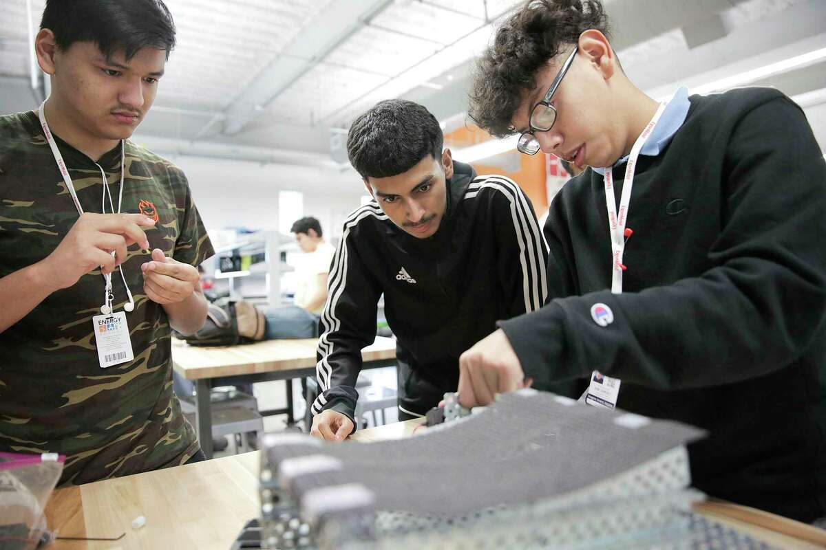 Energy Institute High School robotics students Andrew Torres, from left, Javier Loredo and Rene Ramirez, work on building a robot in 2018.