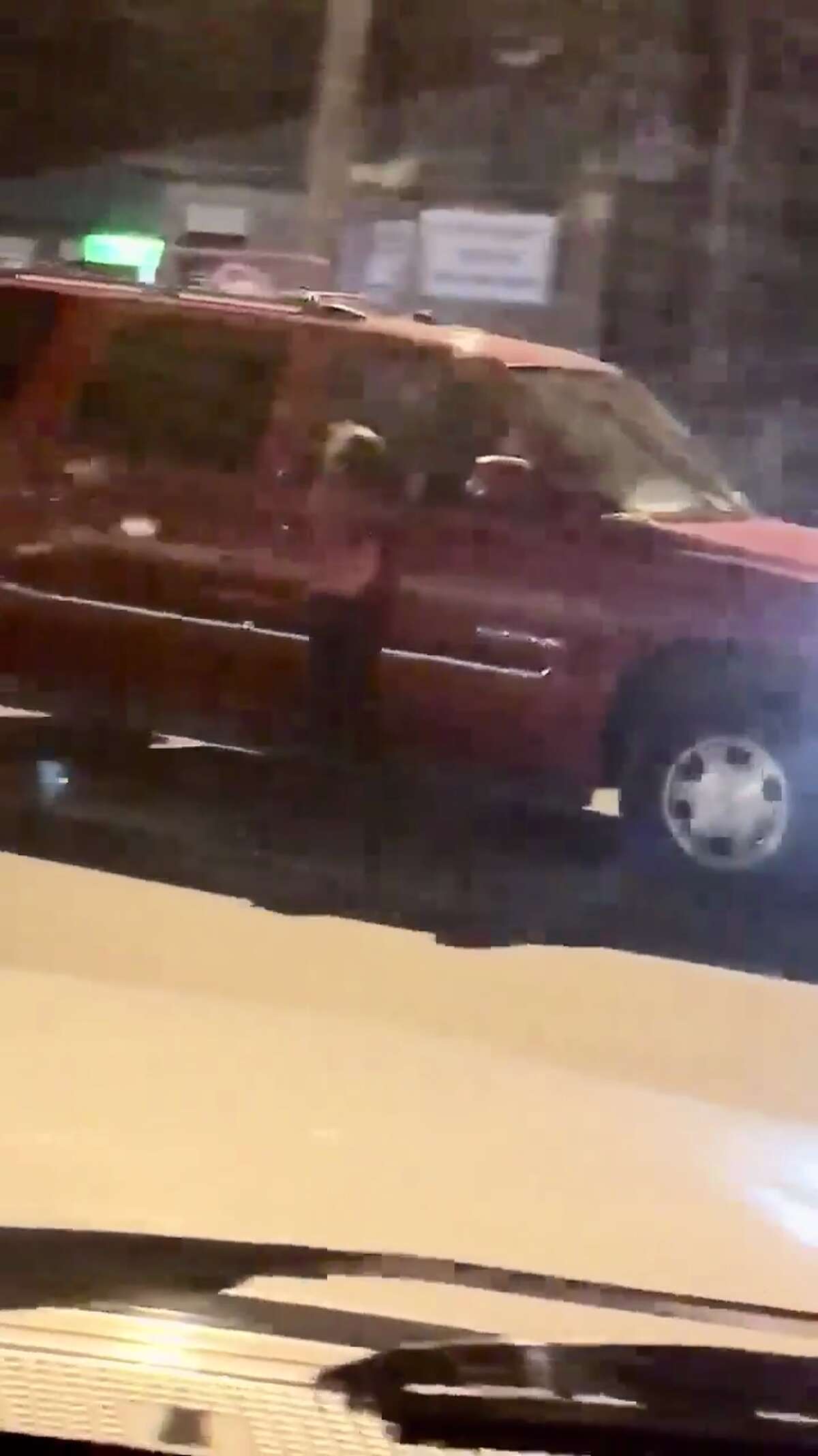Screenshots taken from a shocking video shared by the Laredo Police Department show a child hanging onto a passenger door while an SUV drives through the parking lot of a local business.