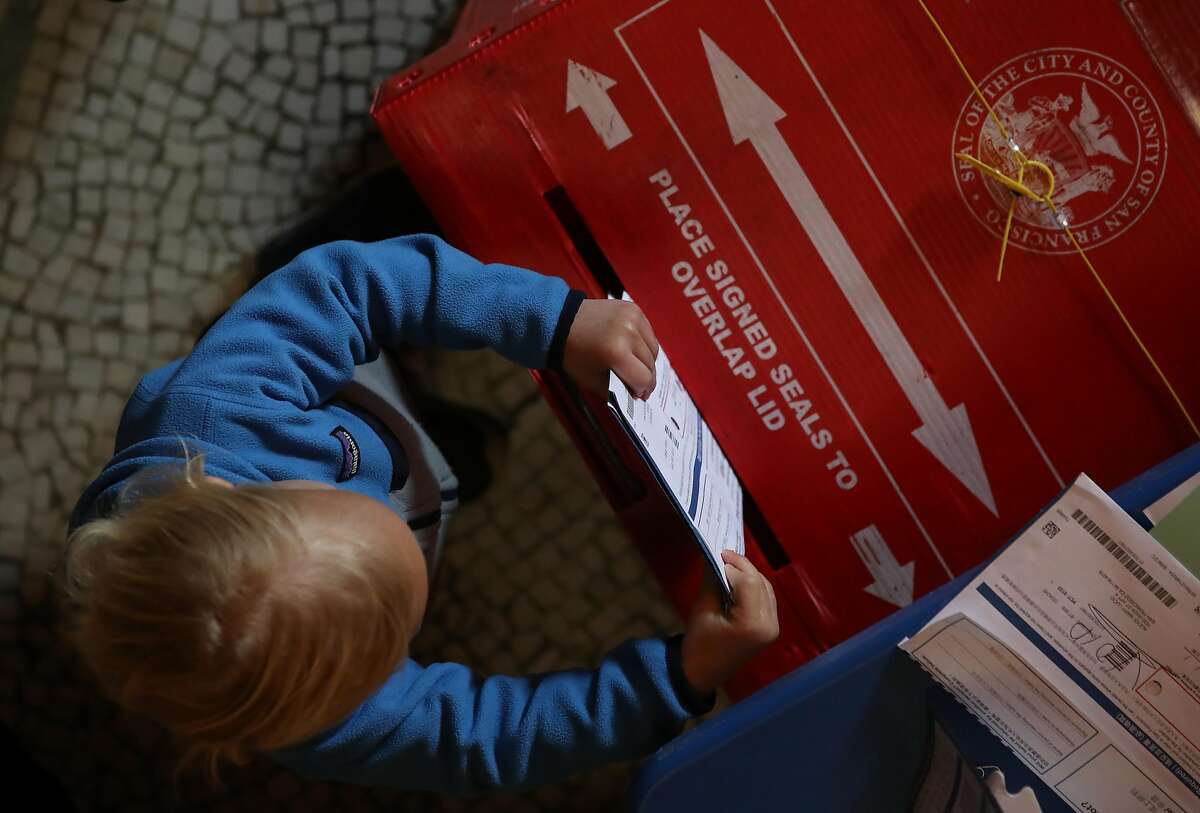 A young boy puts filled out ballots into a box in a polling station at the San Francisco Columbarium & Funeral Home on March 03, 2020 in San Francisco, California. 1,357 Democratic delegates are at stake as voters cast their ballots in 14 states and American Samoa on what is known as Super Tuesday.