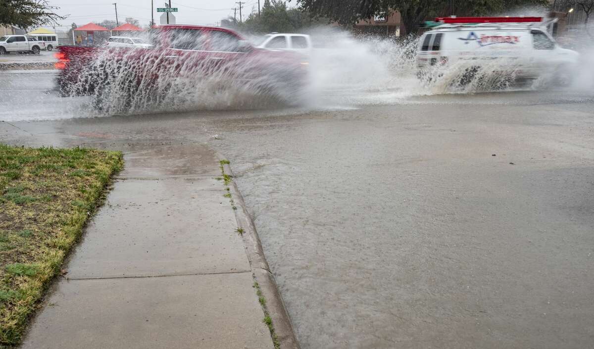 Cars make their way down Big Spring Street this morning as streets around Midland flooded from heavy rains.