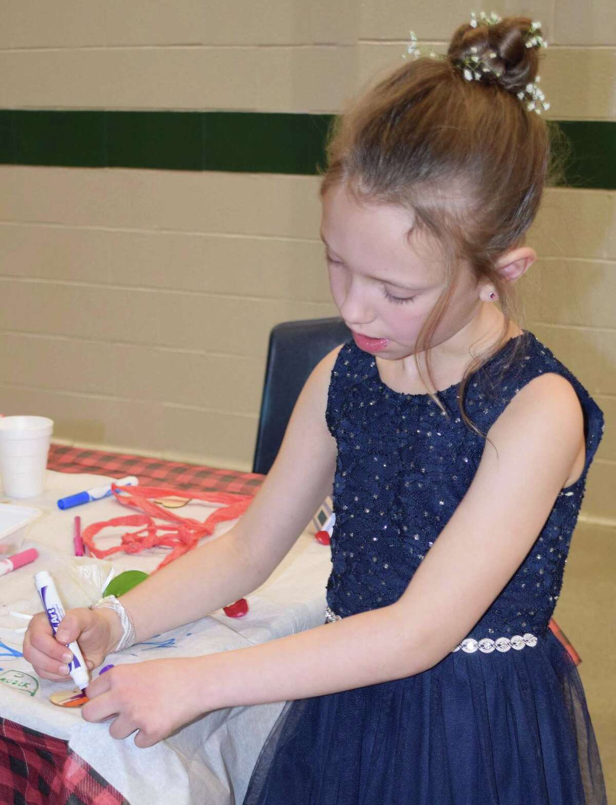 Spectrum/New Milford Girl Scout Troop 40270 hosted the annual Sweetheart Dance at New Milford High School Feb. 22, 2020.The event featured formal photos, a silent auction, dancing, refreshments and more. Above, Ella Kayfus, 7, of New Milford makes the final touches to a craft project.