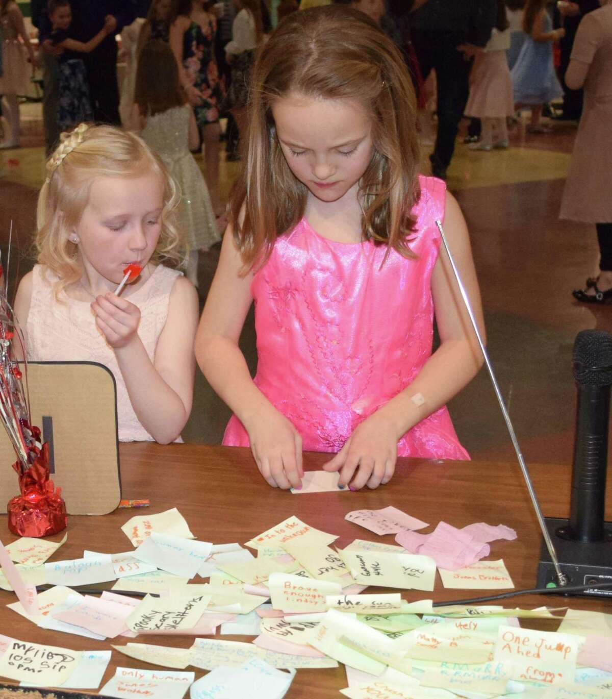 Bailey Larson, left, and Hailey Buturla, both 8 and of New Milford, submit a song they'd like to hear played by the DJ.