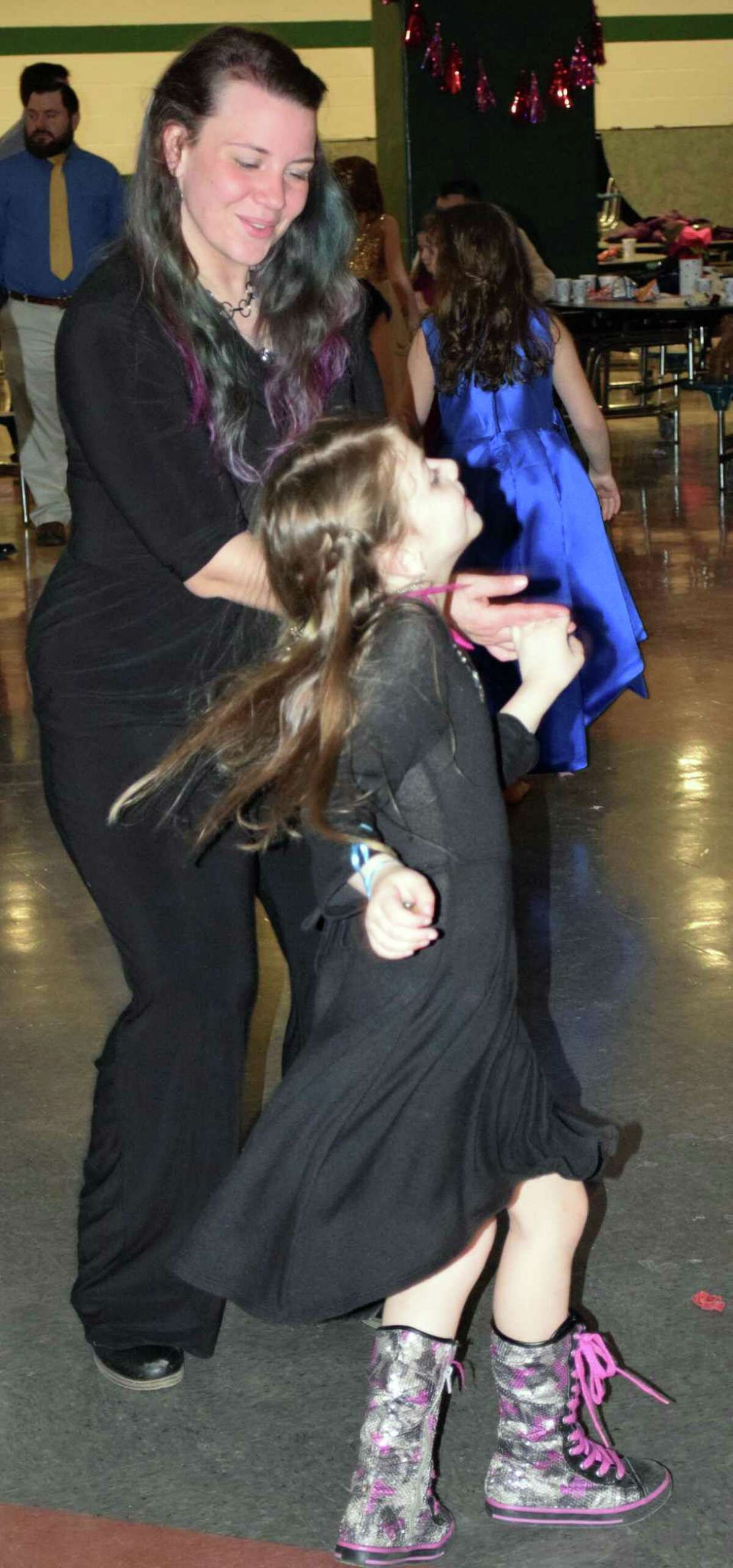 Jasmyne Brown, 7, of New Milford spins around as she dances with her date, her mother, Amanda Mullen.