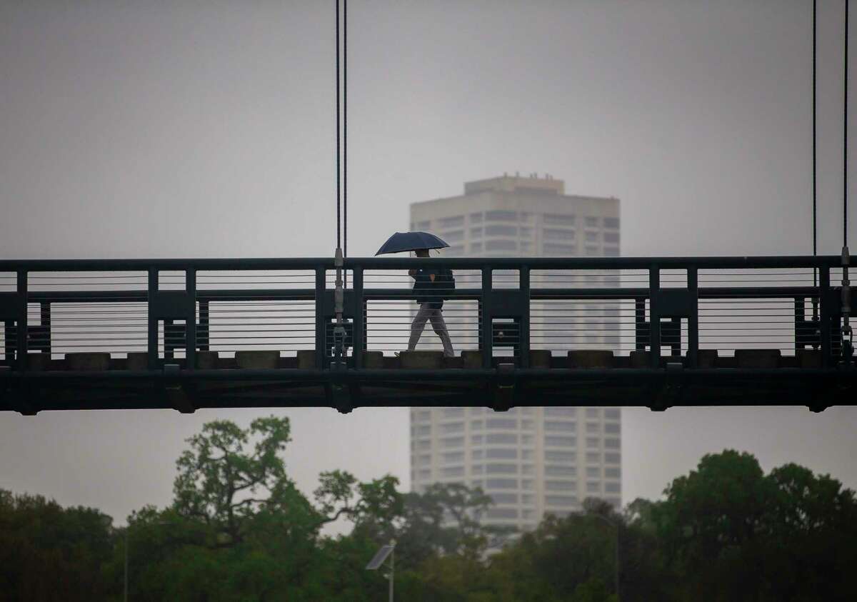 A pedestrian crosses a bridge across Brays Bayou, Wednesday, March 4, 2020, near Hermann Park in Houston.