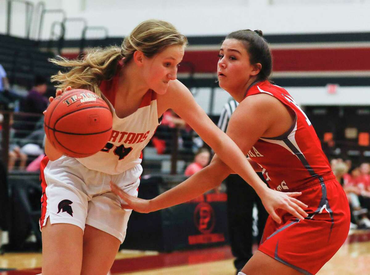 In this file photo, Porter forward Emily Knollenberg (20) drives past Splendora guard Mykala Moore (12) toward the basket during the first quarter of a non-district high school basketball game at Porter High School, Tuesday, Nov. 26, 2019, in Porter.