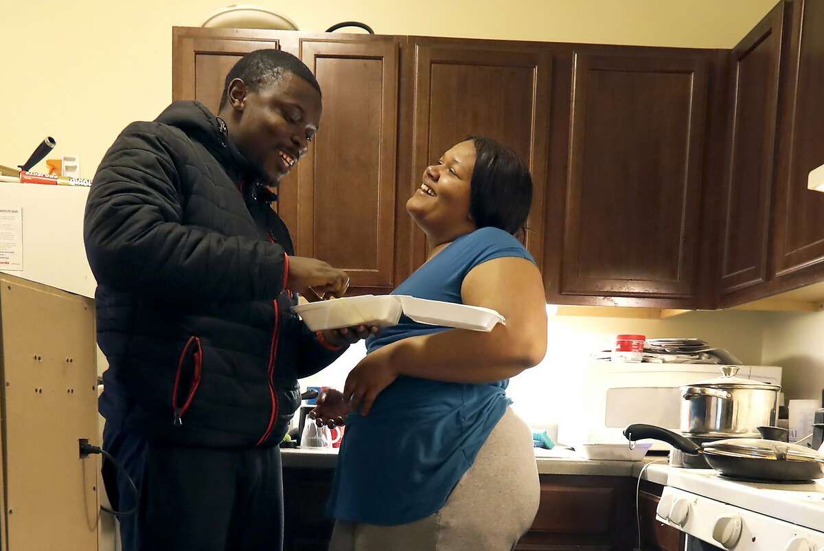 In this Thursday, Feb. 27, 2020, photo, Richard Butler and his fiance Amber laugh while they have breakfast in an apartment a friend is letting them live in on Chicago's Southside. Having food stamps offers Butler a stability he's rarely known in his 25 years. But that stability is being threatened for people like him, who are able-bodied, without dependents and between the ages 18 and 49. (AP Photo/Charles Rex Arbogast)