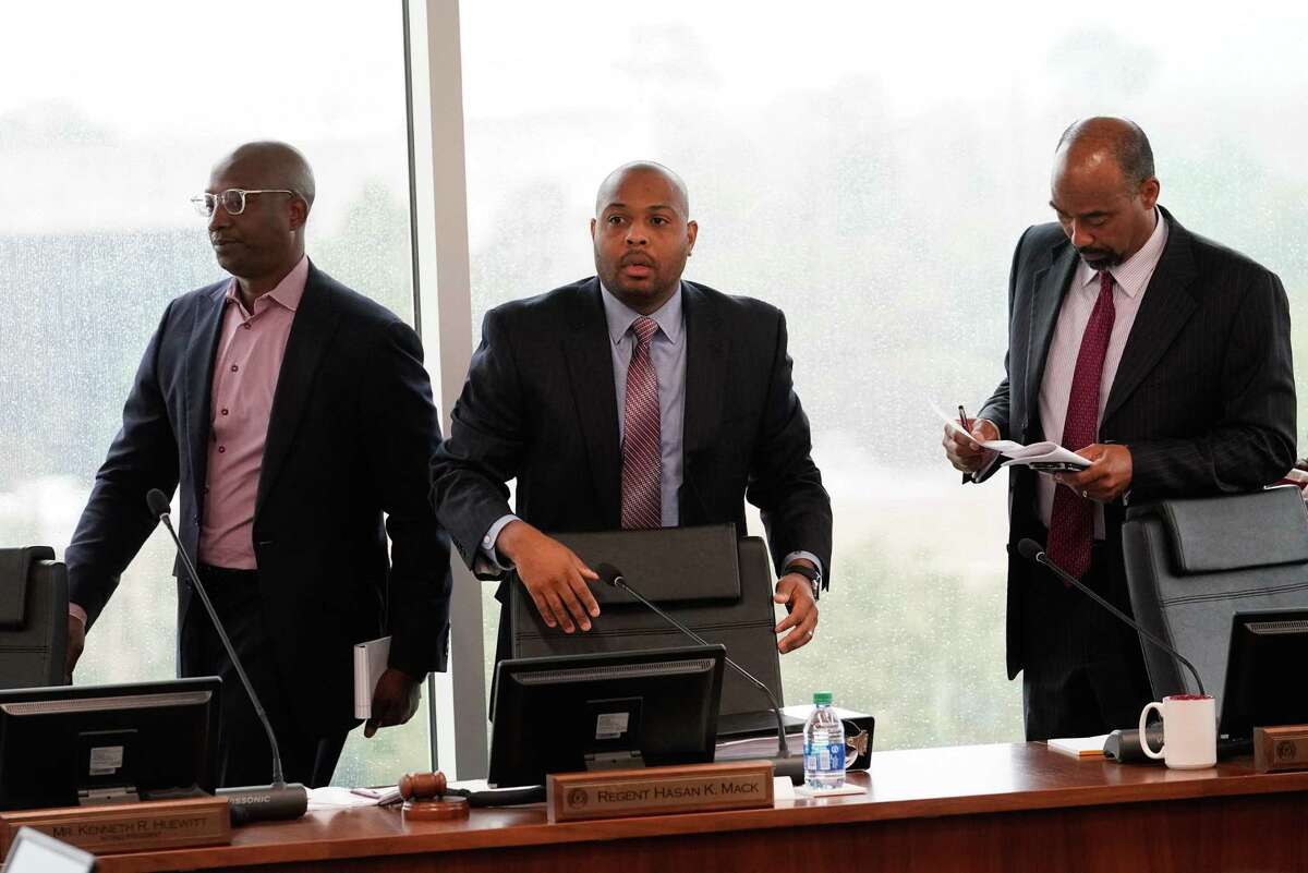 Texas Southern University’s board of regents Derrick Mitchell, left, Hasan Mack, chair, and Albert Myers, vice chair, right, leave board meeting for an executive session Thursday, Feb. 19, 2020 in Houston. The board is meeting for the first time since giving their notice of termination for sidelined TSU president Austin Lane earlier this month.