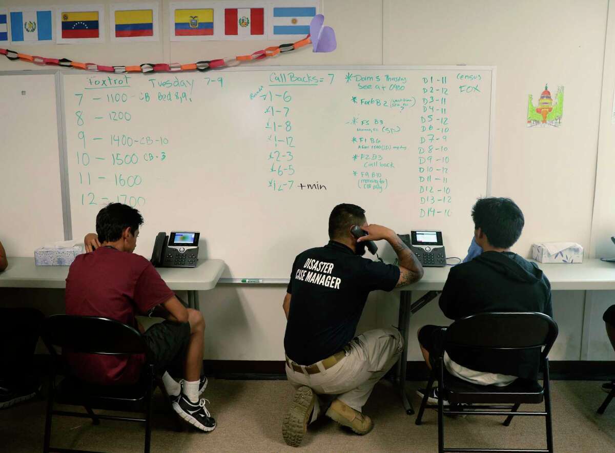 Staff help immigrants make calls to family at the U.S. government's newest holding center for migrant children in Carrizo Springs in July 2019. The Trump administration is now fast-tracking the legal proceedings of thousands of immigrant children in its care, including unveiling a pilot program in Houston to stream their hearings through video technology — a move advocates say will jeopardize their asylum cases and speed up deportations.