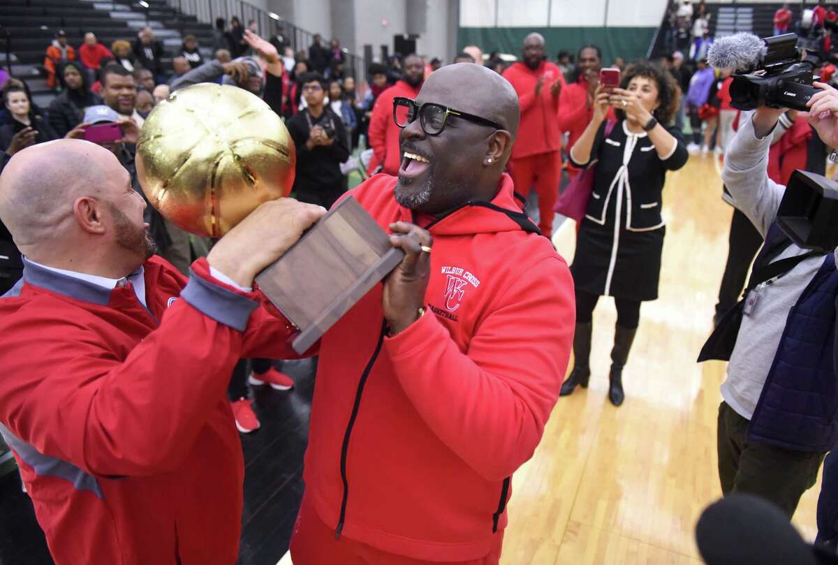 Citywide Athletic Director Erik Patchkofsky, left and Wilbur Cross head coach Kevin Walton hold the trophy after defeating Notre Dame-West Haven in the SCC championship on Wednesday.