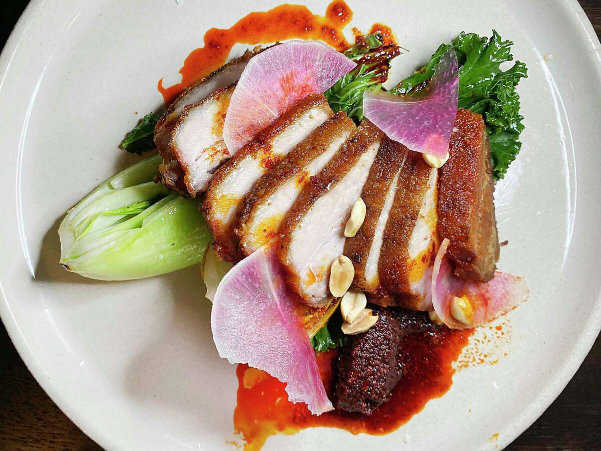 Crispy pork belly incorporates braised gai lan, kale, hot chile oil, peanuts and watermelon radish at The Magpie, a small Korean-inspired restaurant on East Houston Street.