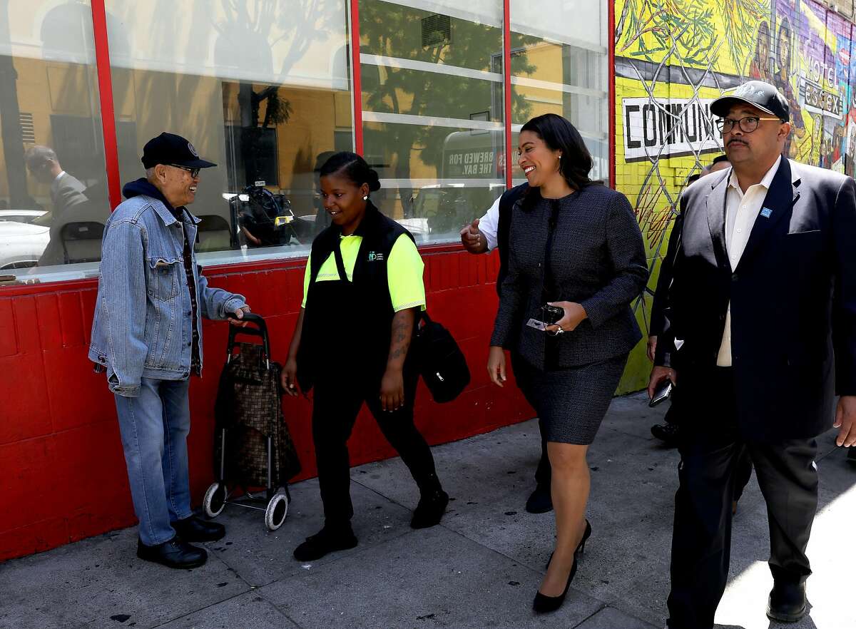 A supporter greets San Francisco Mayor London Breed, third from left, as she participates in a walking tour of the Tenderloin with Jonea Drummer, second from left, community ambassador for Mid Market/Tenderloin, Mohammed Nuru, right, Director of Public Works and other department heads on Friday, July 13, 2018, in San Francisco, Cali.