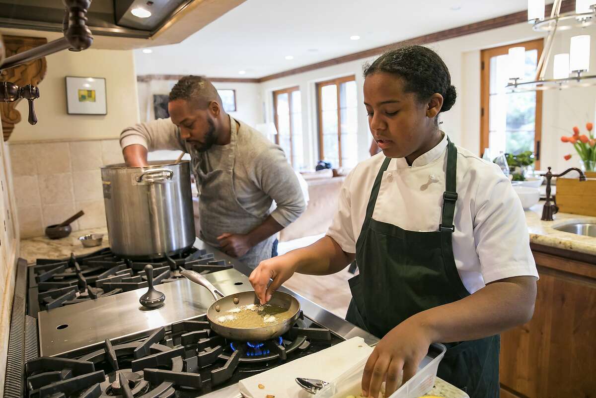 From right to left, Rahanna Bisseret Martinez, 16, and Chef Bryant Terry prepare food for a dinner party at the home of Michele and Harry Elam on Saturday, Feb. 29, 2020 in Redwood City, Calif.