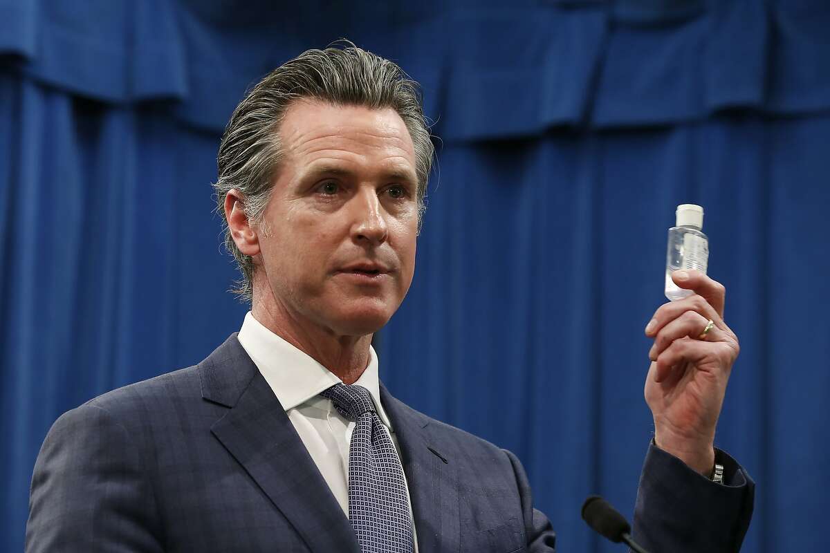 California Gov. Gavin Newsom displays a bottle of hand sanitizer at a Capitol news conference in Sacramento, Calif., Wednesday, March 4, 2020.