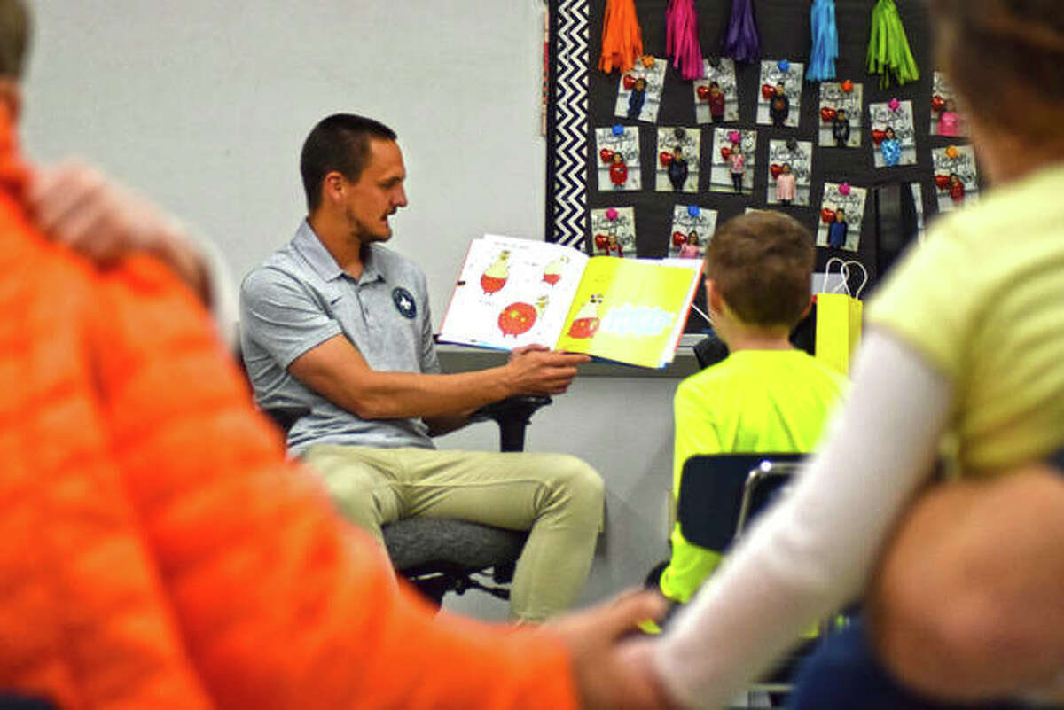 Professional soccer player for the St. Louis FC, Sam Fink, reads a Dr. Seuss book to a classroom full of District 7 students and family during Read Across America at Woodland Elementary School Thursday night.