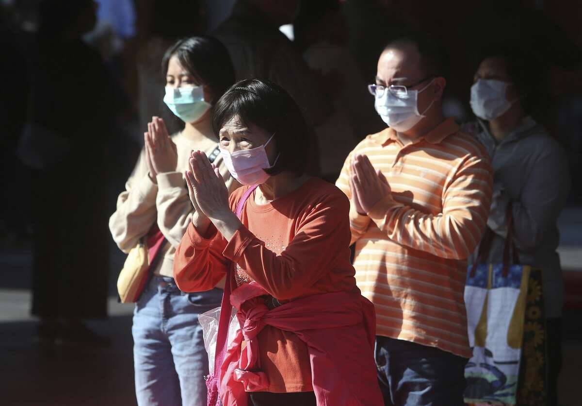 Worshippers wear face masks to protect against the spread of the coronavirus as they pray at the famous Hsing Tian Kong Temple in Taipei. Taiwan's timely, efficient response to the outbreak has saved lives.