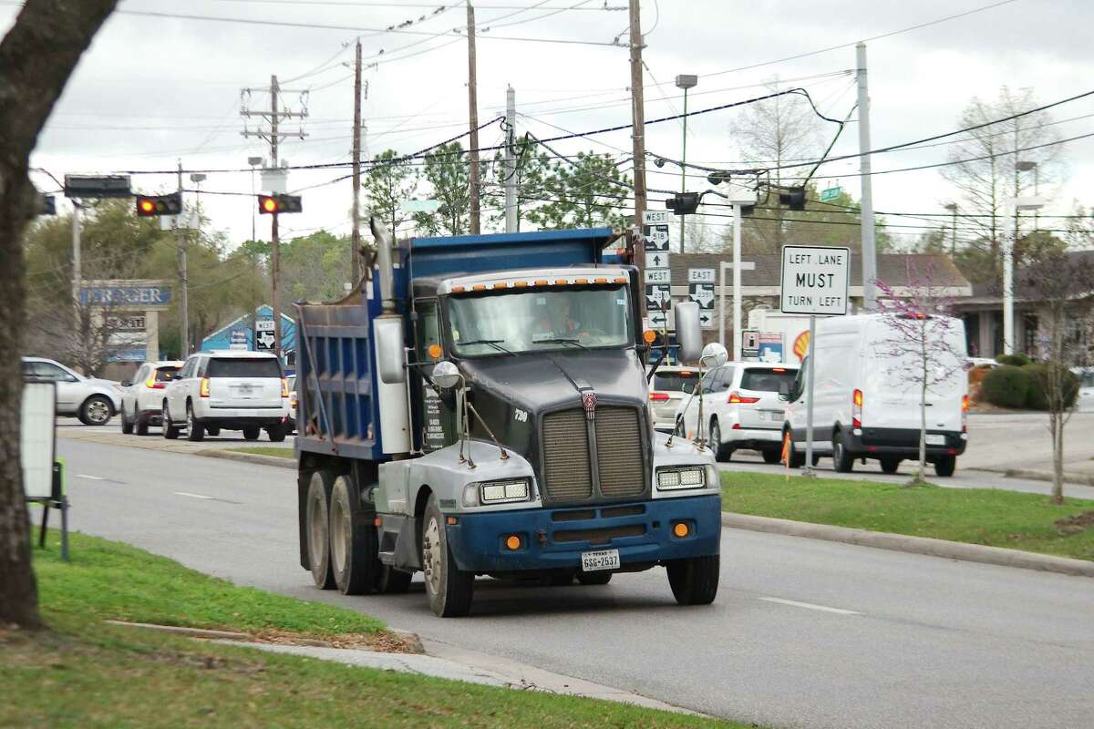 Here comes another one: a loaded dump truck heads east on FM 518 in Friendswood carrying dirt from the site of a massive flood control project.