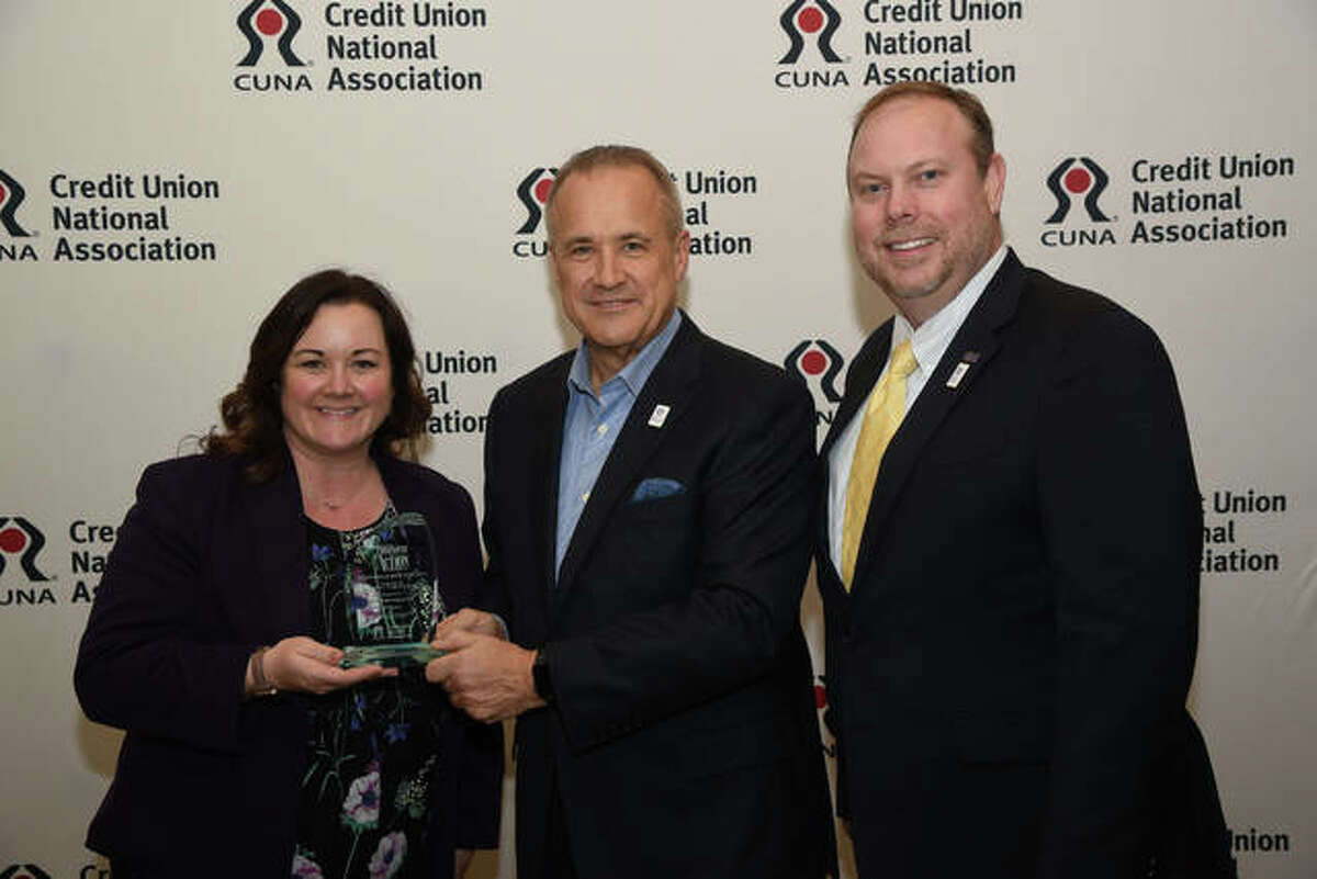Amber Scott, Vice President of Marketing and Communication, and James Cherry, CIO, at 1st MidAmerica Credit Union, receive an award from Jim Nussle, President of the Credit Union National Association.