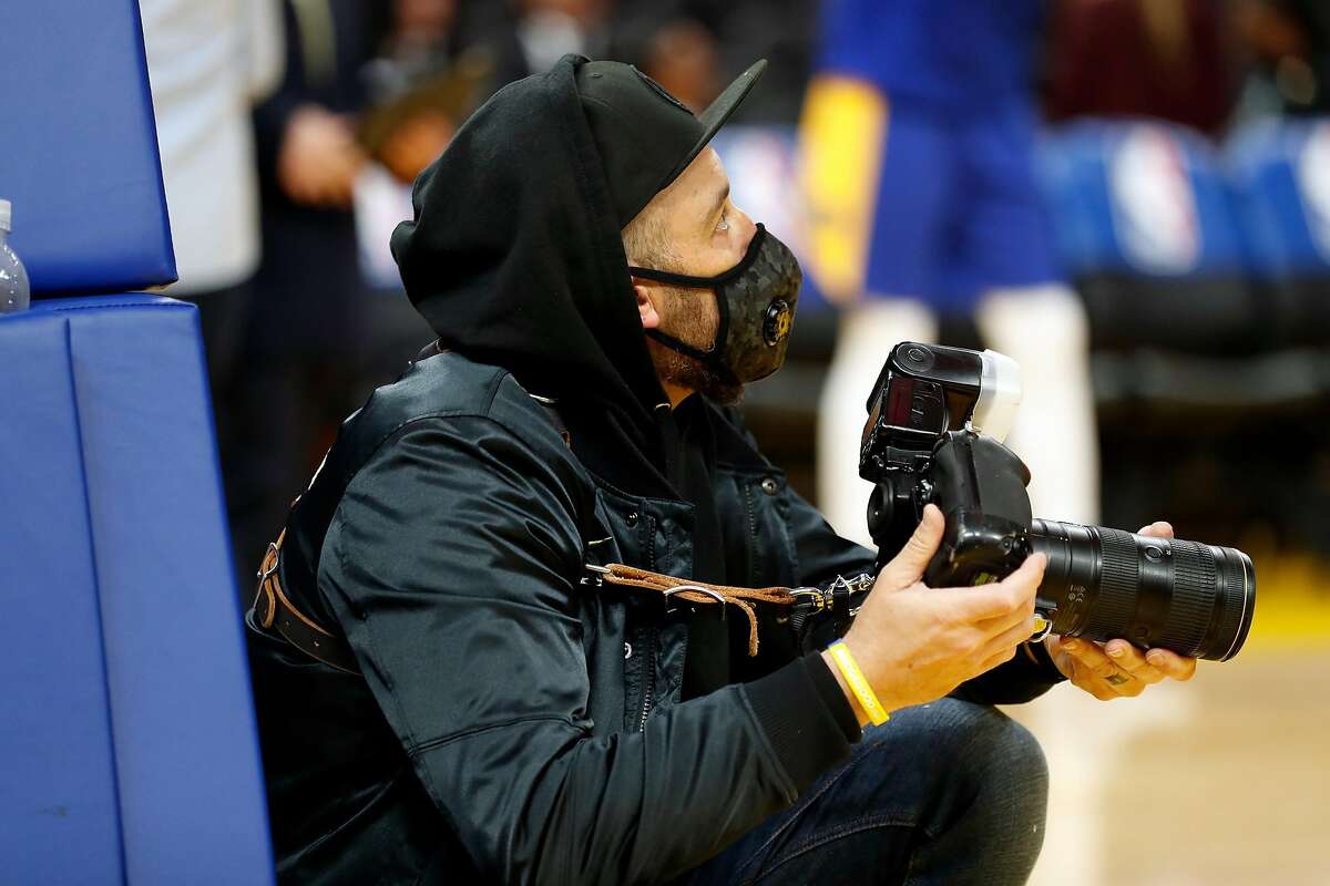 Golden State Warriors' team photographer Noah Graham wears a protective mask before Warriors' game against Toronto Raptors at Chase Center in San Francisco, Calif., on Thursday, March 5, 2020.