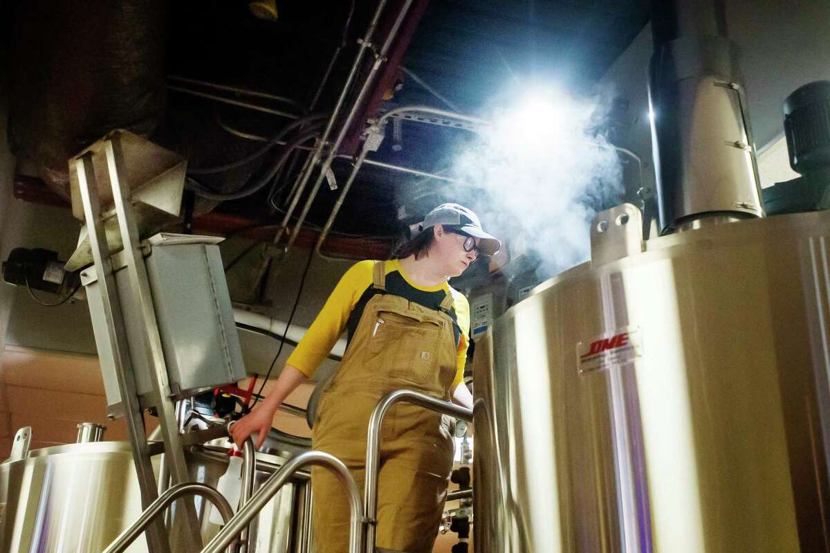 Leah Witkoske, a brewer at Midland Brewing Company, peers down into a boil kettle as she brews a batch of beer Thursday at Midland Brewing Company. Witkoske has invited female Michigan brewers, as well as female community members and MBC staff, to join her this Sunday in crafting a beer she formulated in honor of International Women's Day and International Women's Collaboration Brew Day, which both fall on Sunday. (Katy Kildee/kkildee@mdn.net)