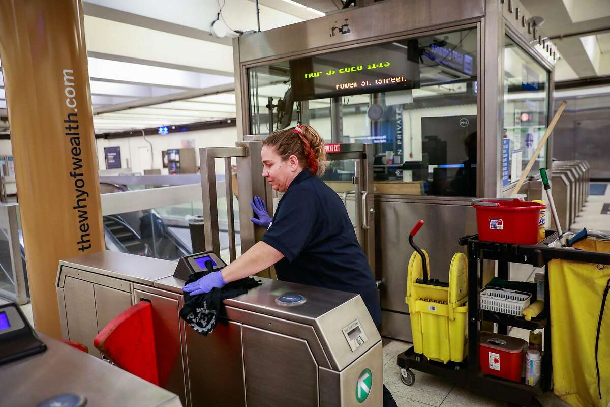 Bobbi Vittori cleans the turnstiles at the Montgomery BART station on Thursday, March 5, 2020 in San Francisco, California. BART is taking precautionary measures to prepare for the potential spread of Coronavirus.