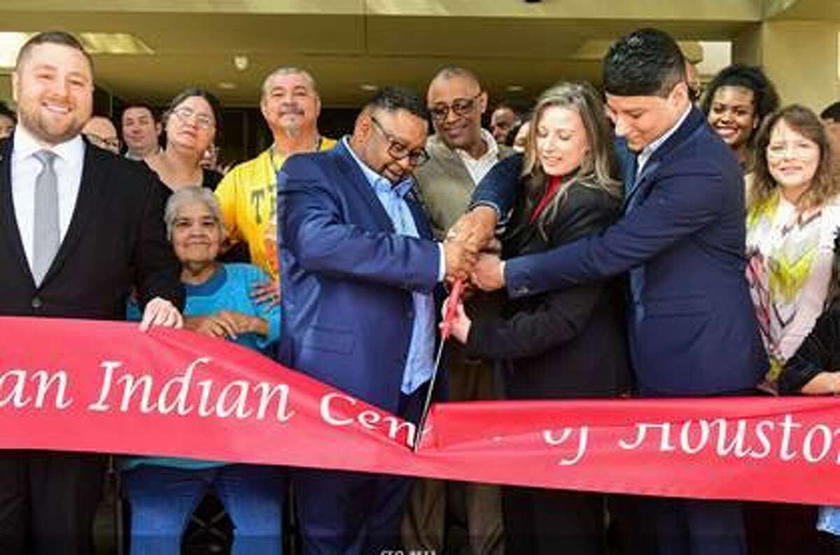 (Left, Blue suit) Marshall Ray Sampson, Vice Chariman of the Tunica-Biloxi Tribe of Louisiana, cuts the ribbon with Nikki McDonald (Center), Director of American Indian Center of Houston and Jeremy Zahn (Right), Council Member of the Tunica-Biloxi Tribe of Louisiana.