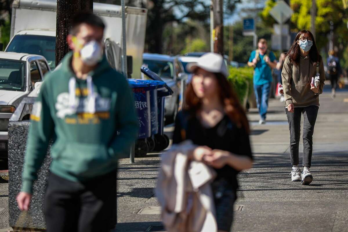 People wear masks while walking on Durant Avenue on Wednesday, March 4, 2020 in Berkeley, California. A Berkeley resident recently tested positive to the coronavirus.