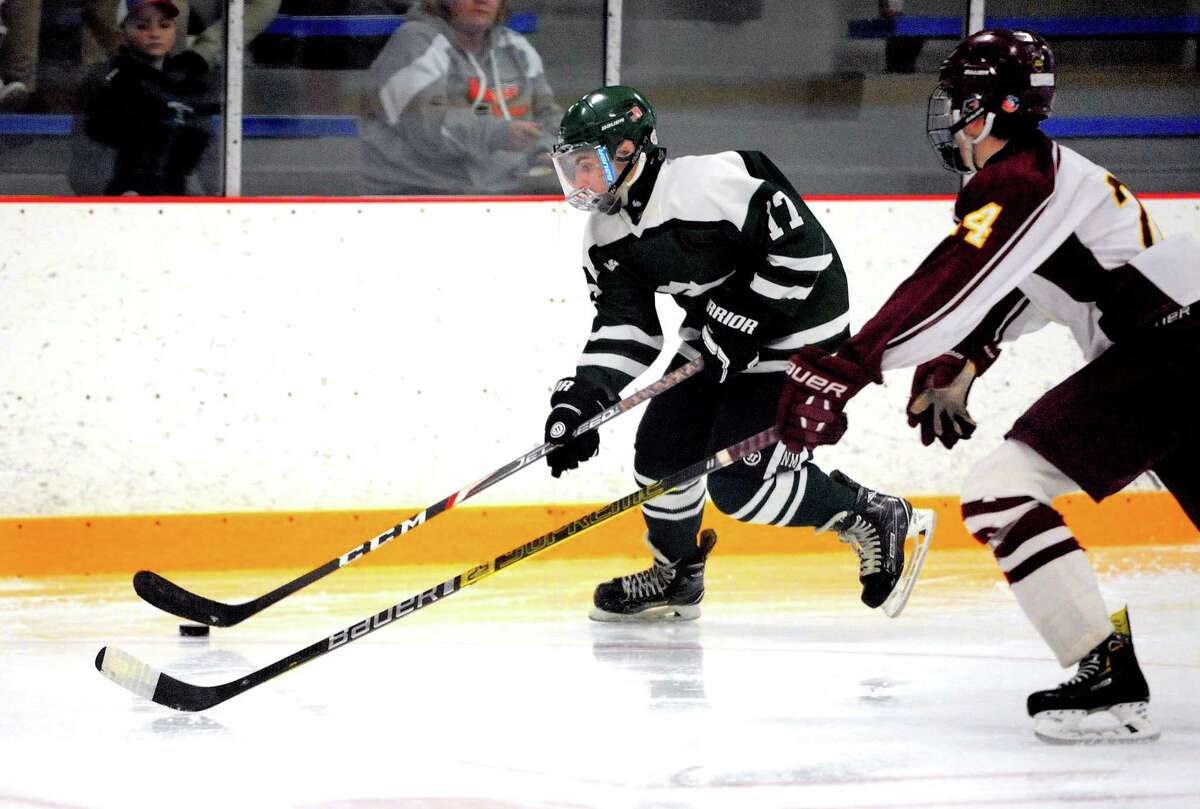 New Milford's Daniel Gallagher (17) drives the puck as Sheehan's James Stratton (24) chases during SCC Div. III Championship hockey action in West Haven, Conn., on Friday Mar. 6, 2020.