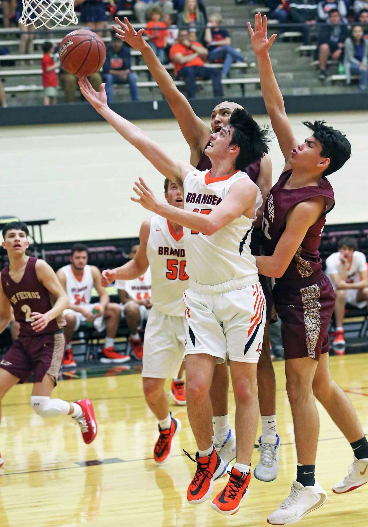 Brandeis guard Andrew Lazinbat gets past defenders for a layup as the Broncos play Los Fresnos on Class 5A regional semifinal basketball at Littleton Gym on Feb. 6, 2020.