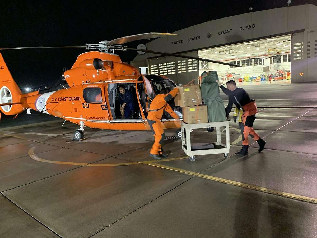Coast Guard Air Station San Francisco crew members load personal protective equipment into an MH-65 Dolphin helicopter Mar. 6, 2020. The Coast Guard continues to support the CDC, state and local health officials for matters involving the Grand Princess. (U.S. Coast photo by Air Station San Francisco)