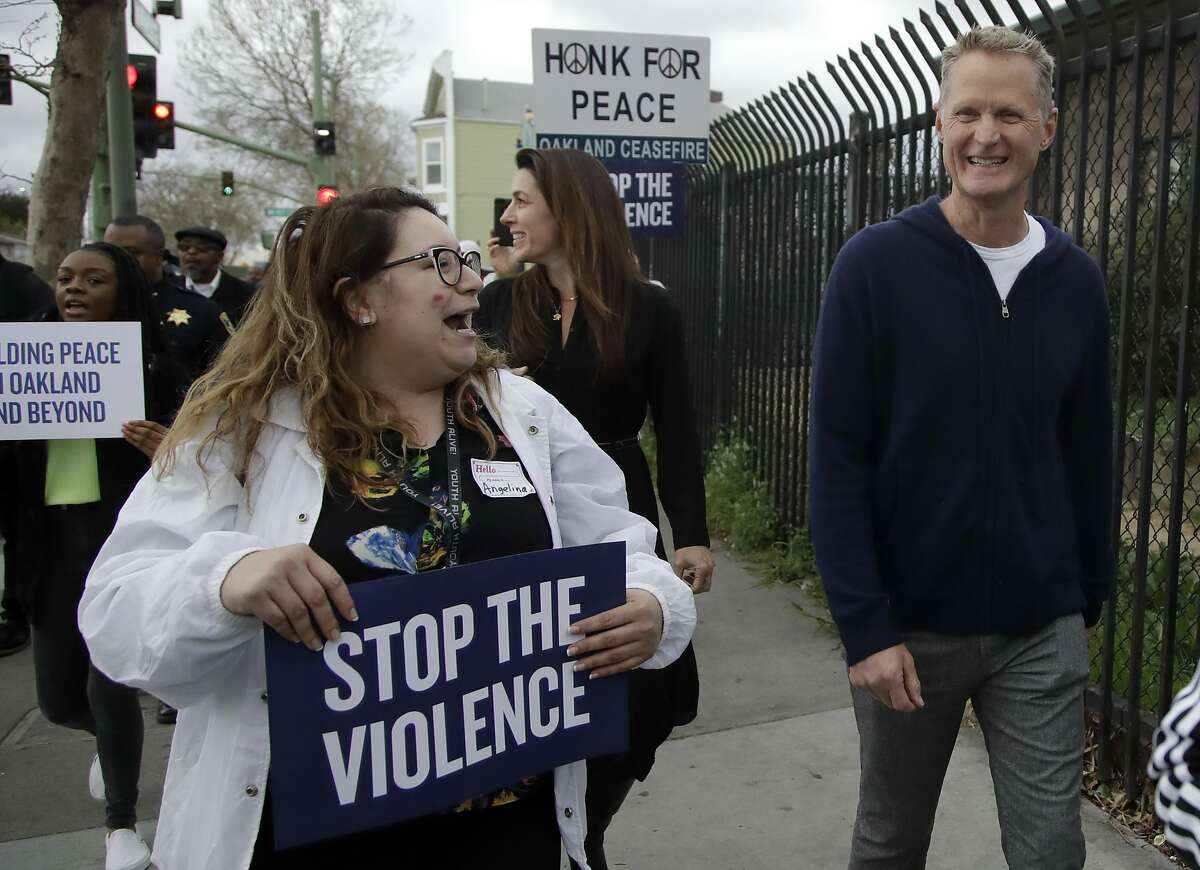 Golden State Warriors' coach Steve Kerr, right, walks in a peace march Friday, March 6, 2020, in Oakland, Calif. Kerr participated in 'Building Peace in Oakland and Beyond', a multi-part event to showcase the impact of Oakland's lifesaving gun violence reduction programs and look at opportunities to expand the successes seen in the Bay Area community. (AP Photo/Ben Margot)