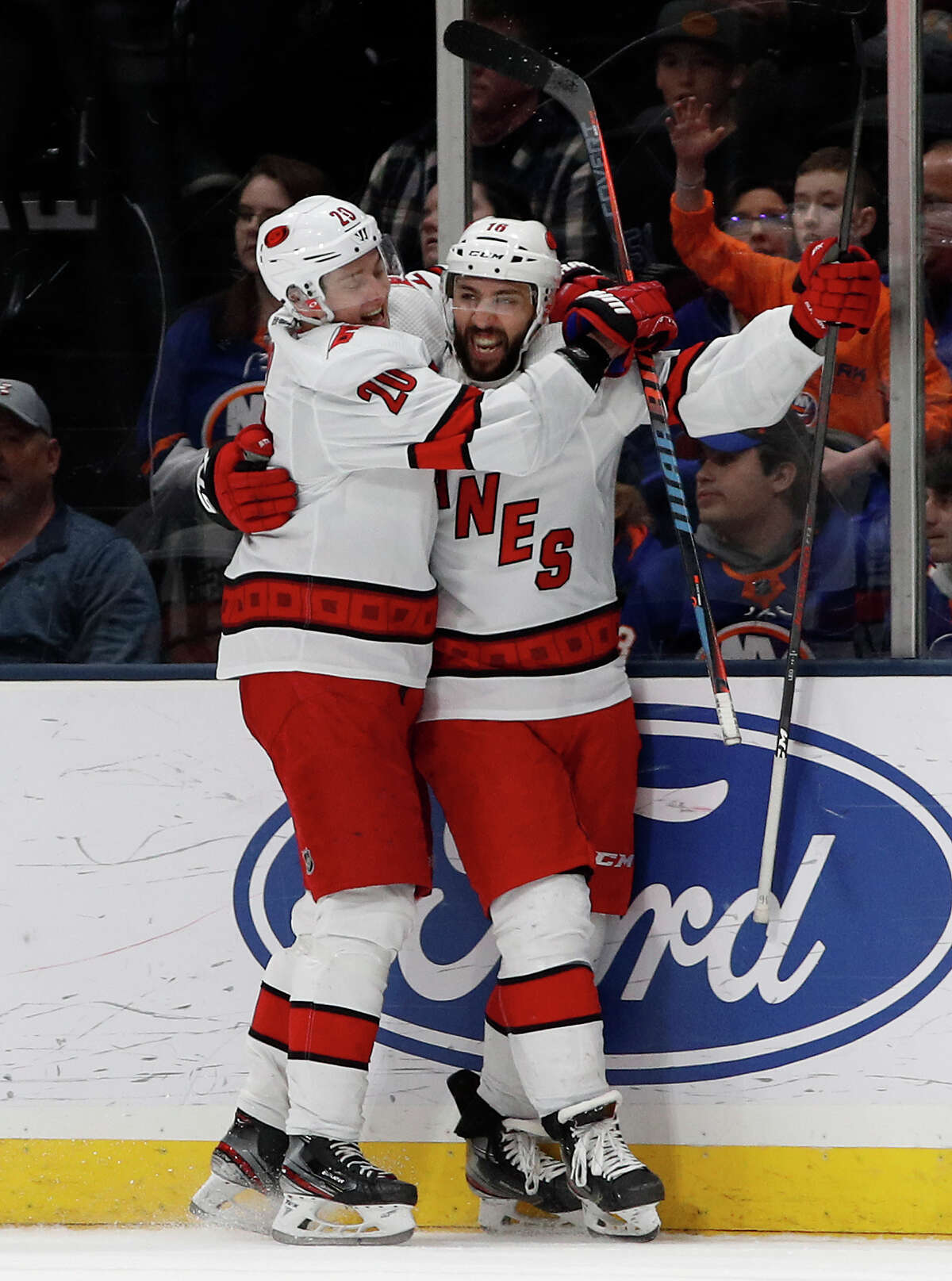 Carolina Hurricanes center Vincent Trocheck (16) celebrates with teammate Sebastian Aho after scoring the game winning goal in overtime during an NHL hockey game against the New York Islanders, Saturday, March 7, 2020, in Uniondale, NY. (AP Photo/Jim McIsaac)