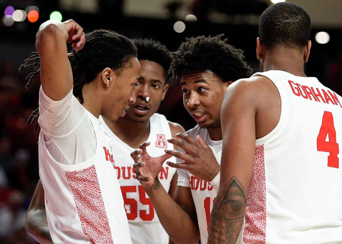 Houston guard Nate Hinton, second from right, talks to Caleb Mills, left, as Brison Gresham (55) and Justin Gorham (4) watch during the first half of an NCAA college basketball game against Memphis, Sunday, March 8, 2020, in Houston.