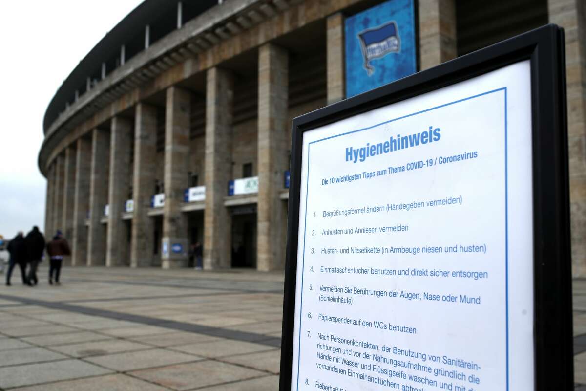 BERLIN, GERMANY - MARCH 07: A sign about Coronavirus is handed out prior to the Bundesliga match between Hertha BSC and SV Werder Bremen at Olympiastadion on March 07, 2020 in Berlin, Germany. (Photo by Maja Hitij/Bongarts/Getty Images)
