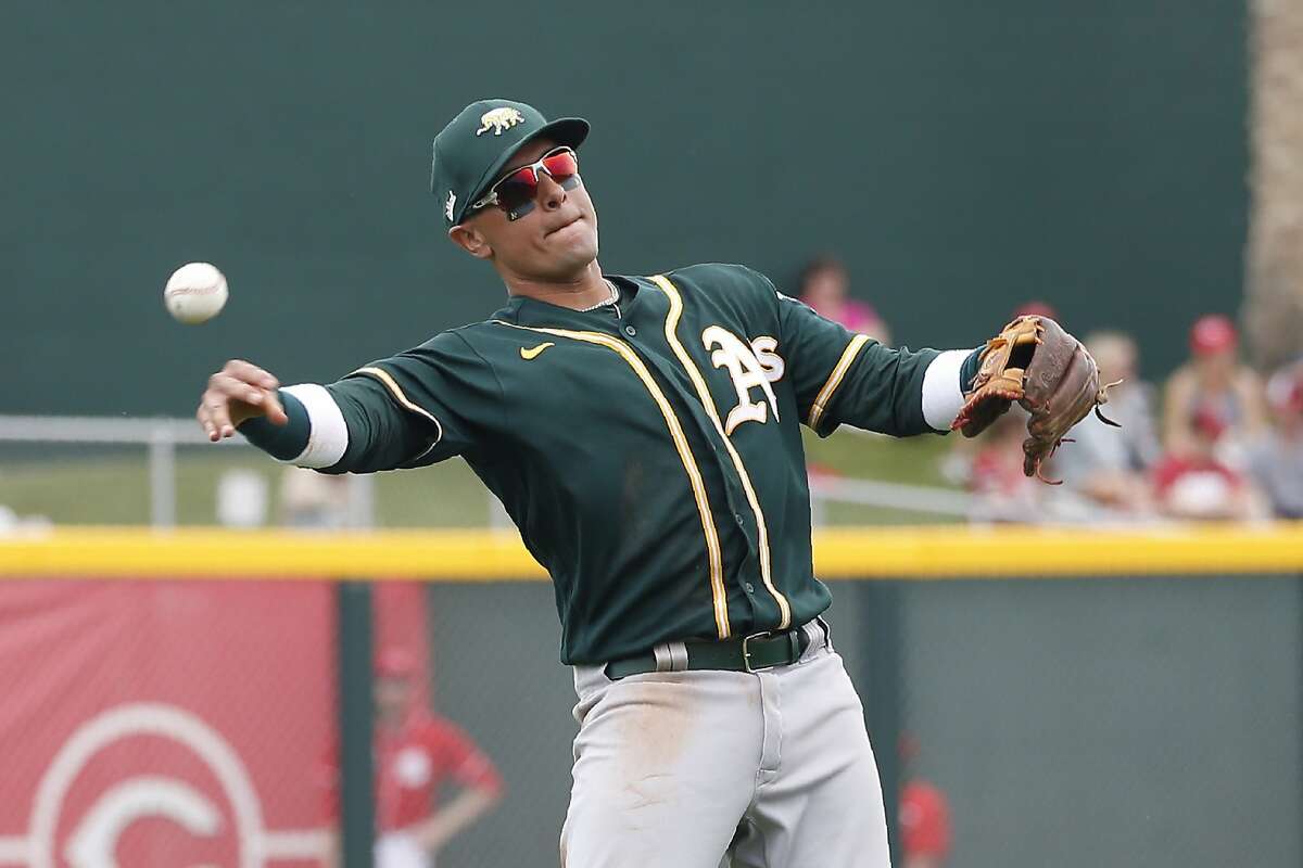 Oakland Athletics shortstop Ryan Goins throws the ball back to the infield during the third inning of a spring training baseball game against the Cincinnati Reds Friday, Feb. 28, 2020, in Goodyear, Ariz. The Reds defeated the Athletics 10-1. (AP Photo/Ross D. Franklin)