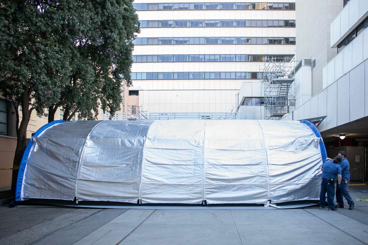 UCSF Facilities Management engineers check the tarp of one of two mobile emergency rooms installed to treat patients triaged for the Coronavirus virus, outside the Emergency Department at the Parnassus Heights campus.