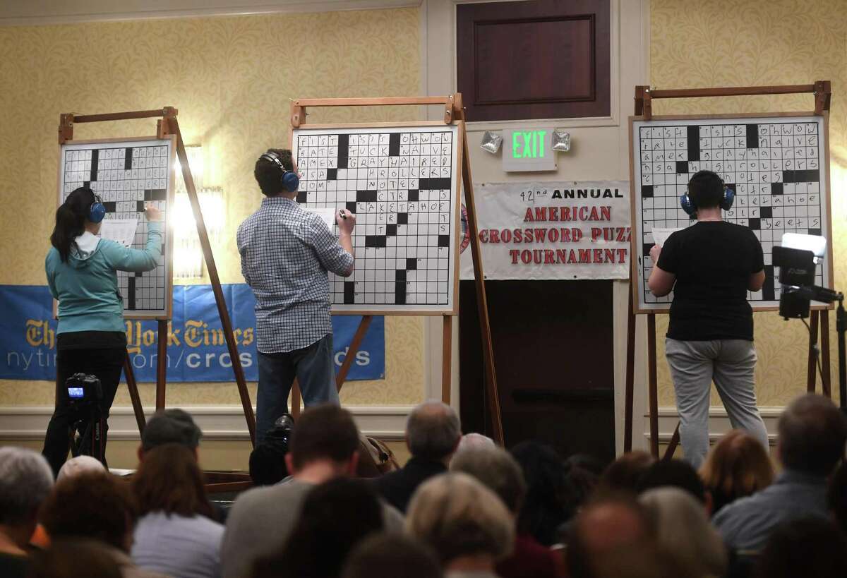 C division contestants complete the championship playoff puzzle on stage at the 42nd Annual American Crossword Puzzle Tournament at the Stamford Marriott in Stamford, Conn. on Sunday, March 24, 2019. The division was won by Lily Geller, left, of Brooklyn, New York.
