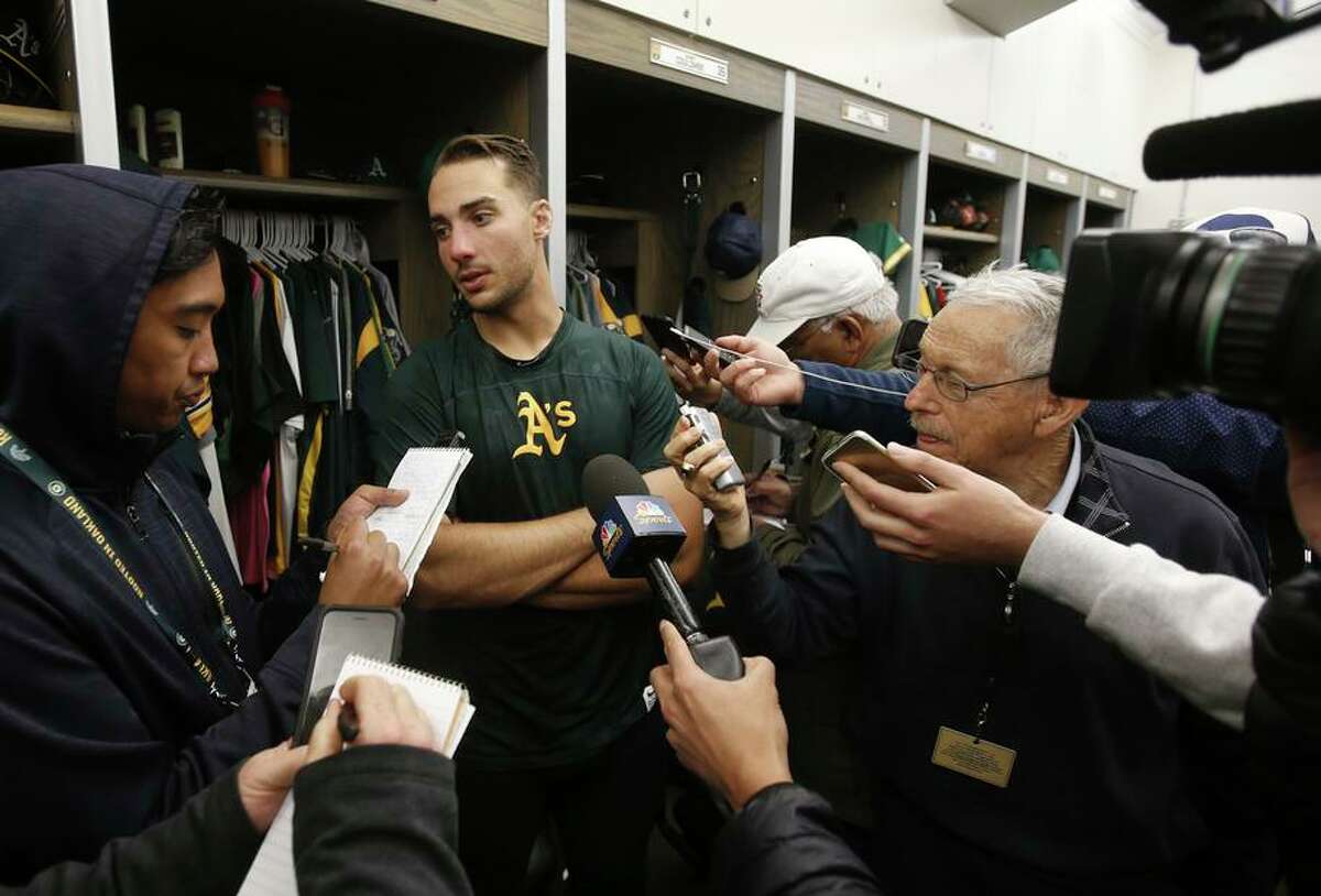 Media scrums like this one in the A’s clubhouse could become a thing of the past with new rules announced by four major sports leagues Monday to maintain social distance because of the spread of the coronavirus.