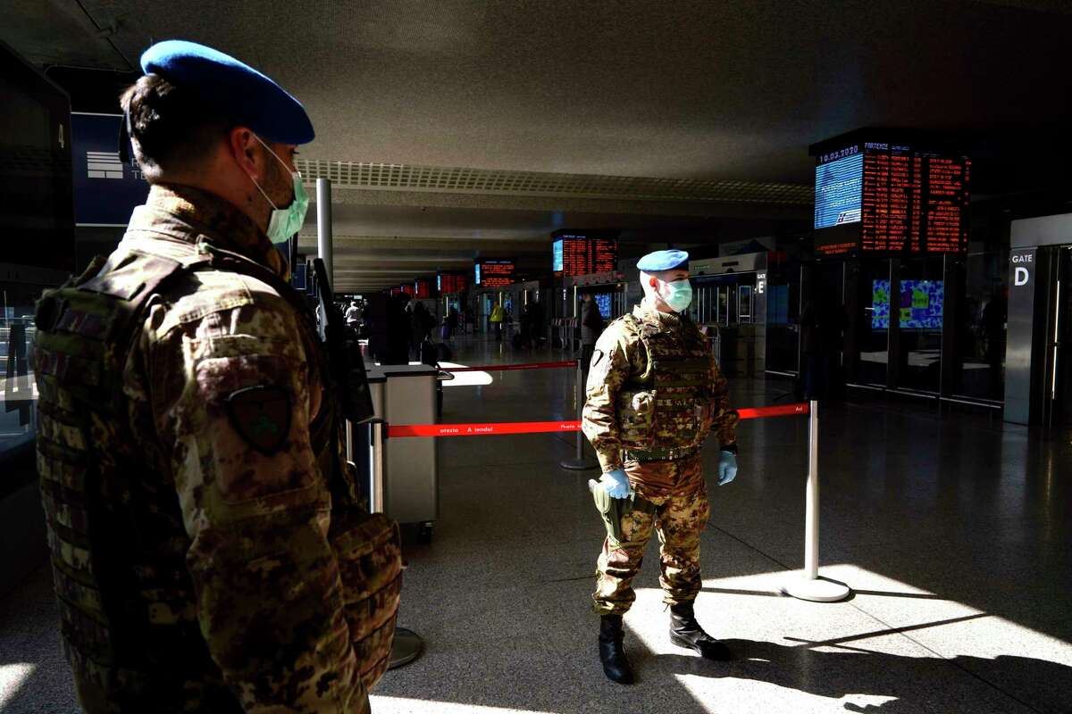 Italian soldiers wear mask as they monitor the travelers' situation inside Rome's Termini train station, Tuesday, March 10, 2020. In Italy the government extended a coronavirus containment order previously limited to the country’s north to the rest of the country beginning Tuesday, with soldiers and police enforcing bans.