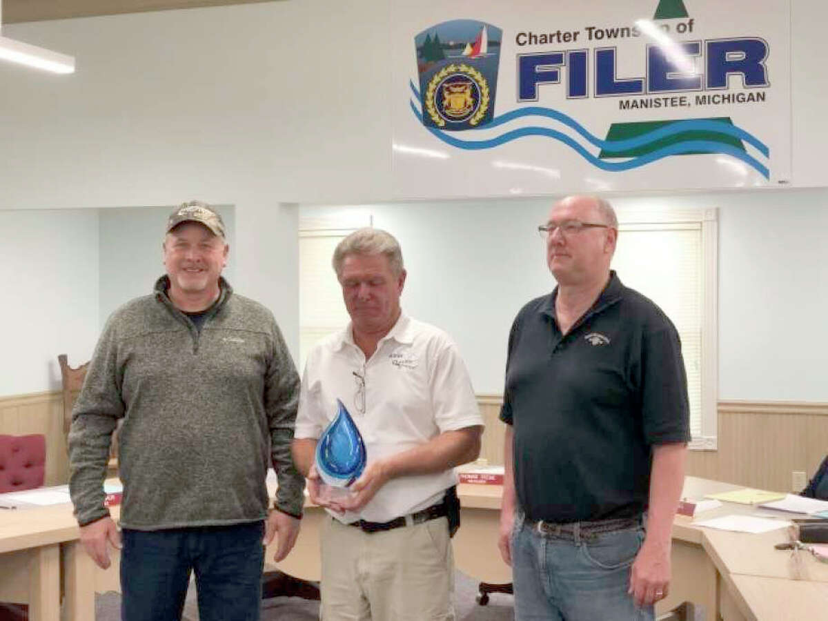 Mike Hiller (left), FilerTownship water operator, and Tom Stege (right), Filer Township treasurer, receive the award from Brian Minor, of the Michigan Rural Water Association.