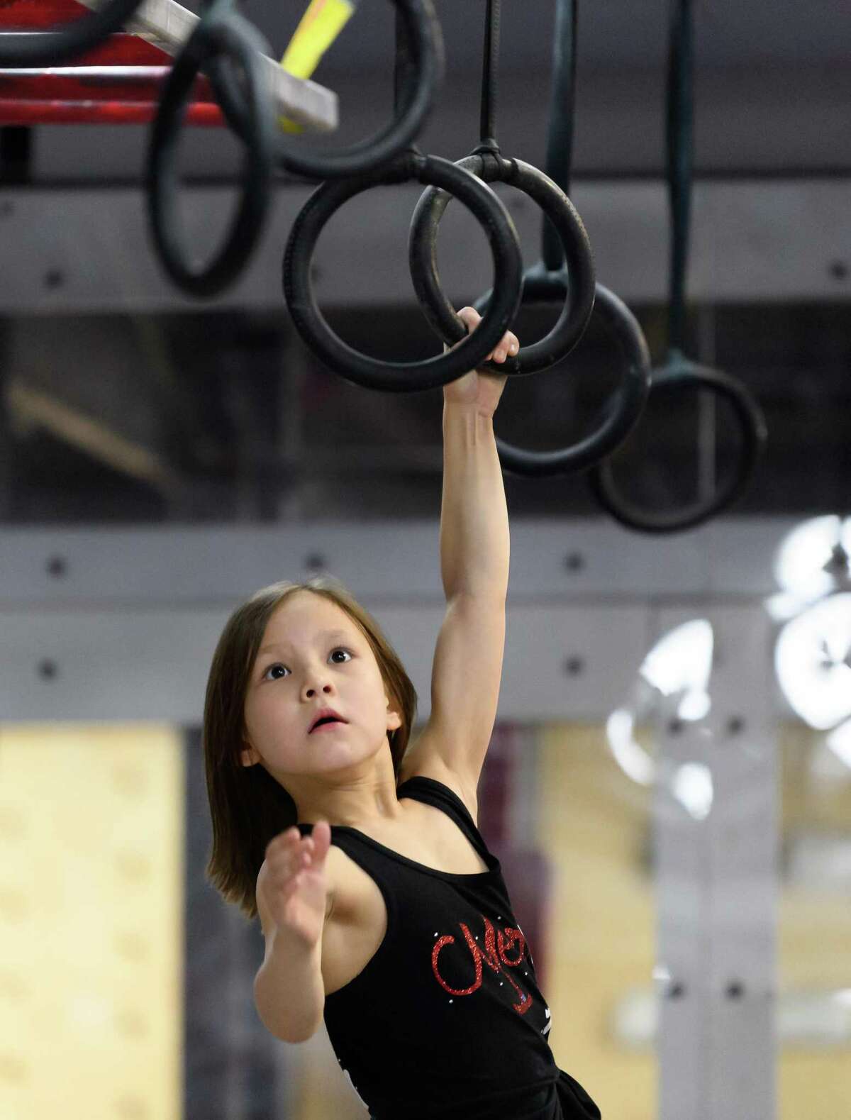 7 year old Maeleigh Kim, Meredith Kim’s younger sister works on the Rings on Friday, March 6, 2020 at Iron Sports in Houston Texas.