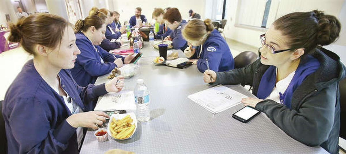Nursing students at Lewis and Clark Community College in Godfrey gather Tuesday at lunch to eat, do homework and check their phones in the snack area of the commons. Area colleges are keeping students up to date on the threat of the COVID-19 virus by email and are meeting with department heads and managers to devise plans if the virus becomes a problem in downstate Illinois.