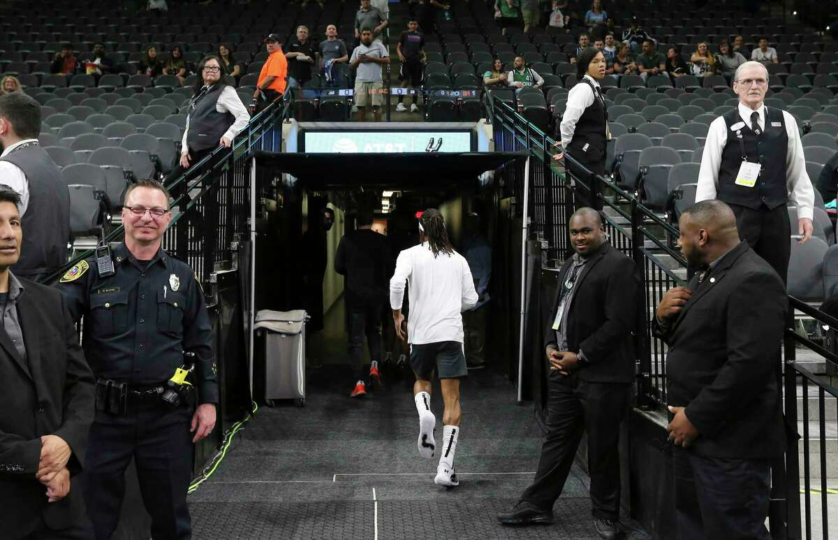 Spurs guard Patty Mills (center) runs toward the locker rooms after warmups before the game against the Dallas Mavericks on Tuesday, Mar. 10, 2020. The NBA has mandated new changes to the way players and coaches engage fans and media. For the San Antonio Spurs, Coach Gregg Popovich is now meeting media in an interview room instead of a scrum-type setting. Media are also no longer allowed in locker rooms post game. Players are also cautioned on how they engage with fans.
