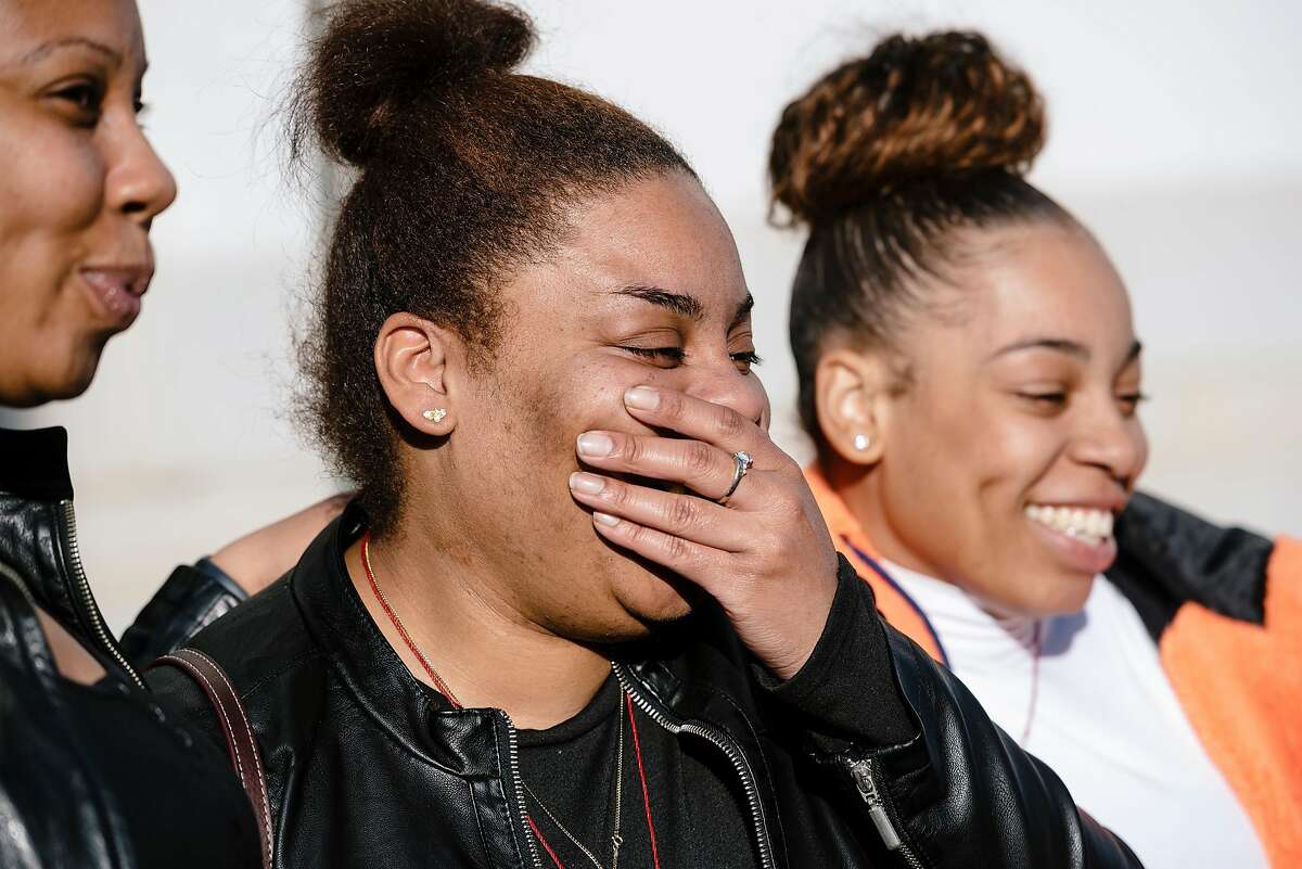 Letifah Wilson, center, and sister and Tashiya Wilson laugh with friends and family following the guilty verdict handed down to defendant John Cowell, who was accused of the fatal 2018 BART station stabbing of their sister Nia Wilson, at the Alameda County Superior Courthouse in Oakland, California, on Tuesday, March 10, 2020.