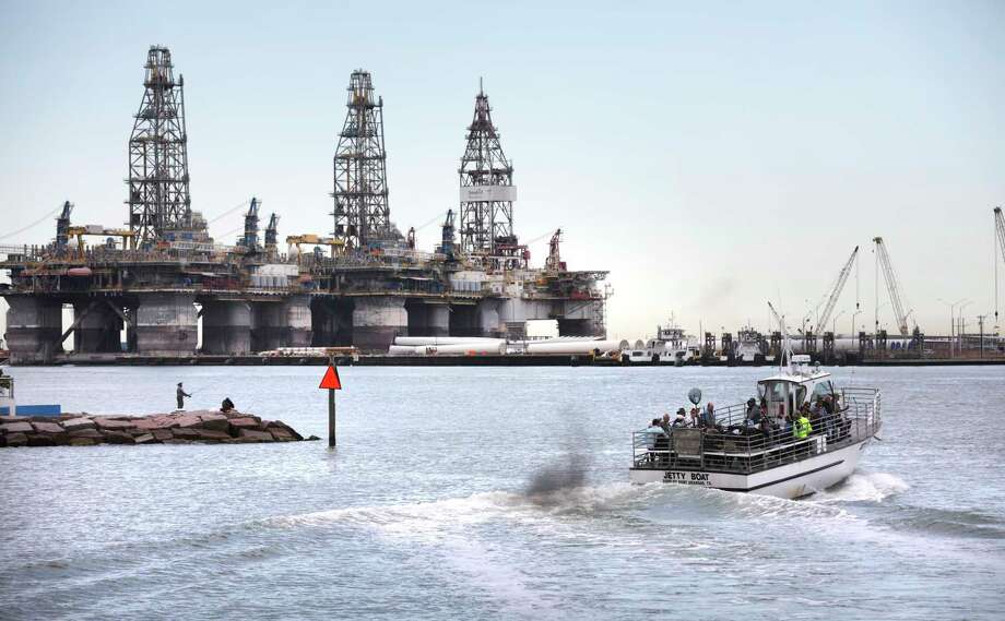 A jetty boat leaves the Port Aransas Marina and passes by massive offshore oil derricks across the ship channel on Harbor Island. The funky beach town is pushing back against a plan to dredge for supertankers and build berths across the ship channel. Photo: Bob Owen / ©2020 San Antonio Express-News