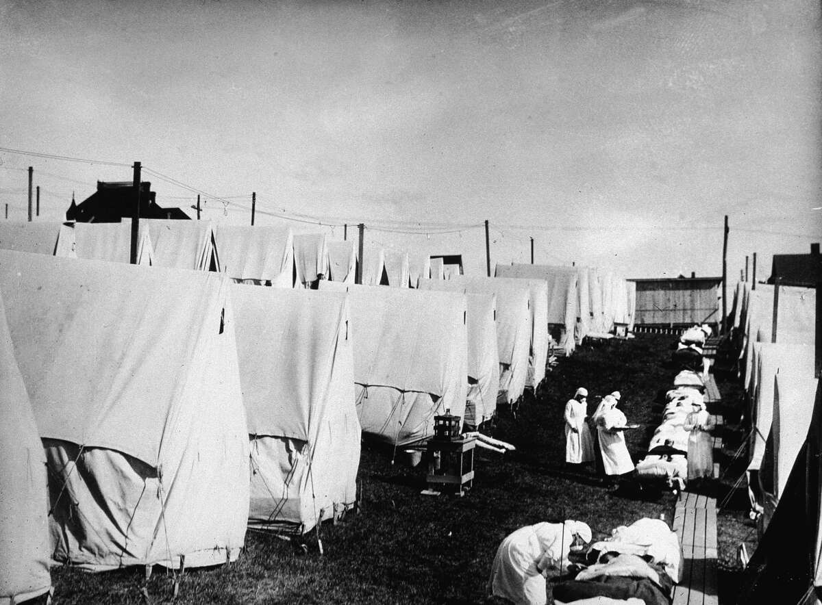 1918 FLU EPIDEMIC: Nurses care for victims of a Spanish influenza epidemic outdoors amidst canvas tents during an outdoor fresh air cure, in Lawrence, Mass., in 1918.