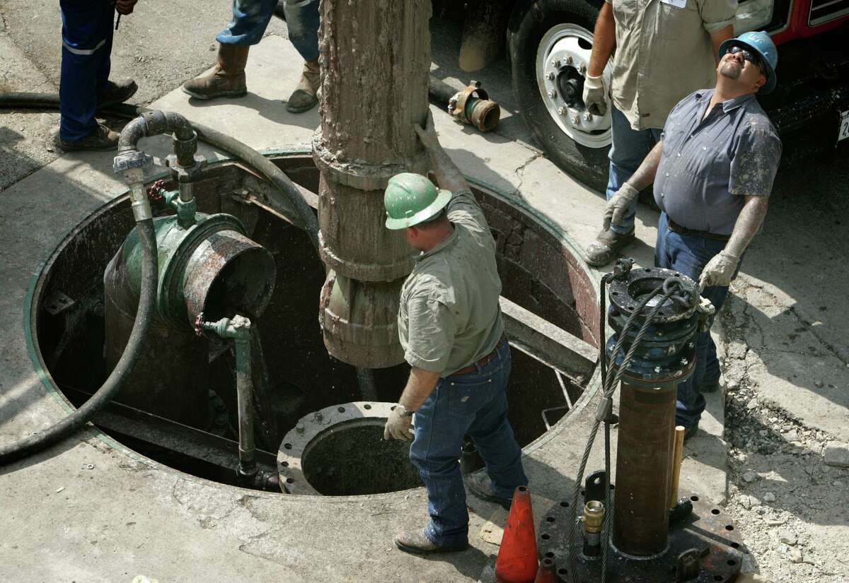 San Antonio Water System workers and other contractors remove a section of pipe 110 feet long from a well in downtown San Antonio in April 2006. City officials are asking SAWS and CPS Energy, the city’s power utility, to temporarily stop disconnecting services for residents who fail to pay their bills during the coronavirus health emergency.
