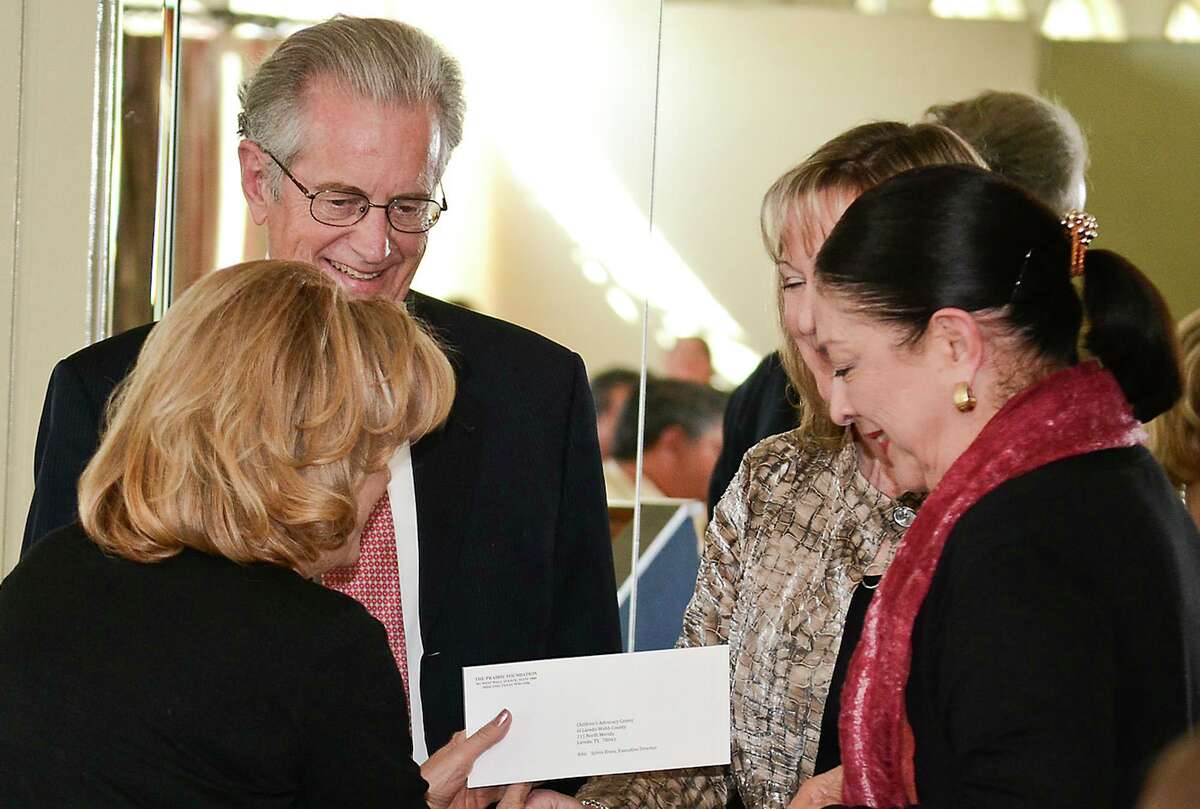 (Background) Norbert Dickman and Linda LaMantia, shake hands with(Foreground) Lorainne Laurel and Sylvia Bruni after being handed a grant check with a value of $10,000 for the Children's Advocacy Center, Thursday afternoon at the San Agustine Ballroom.